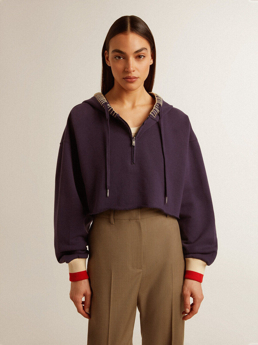 donkerblauwe cropped sweater met ritssluiting en geborduurde capuchon.