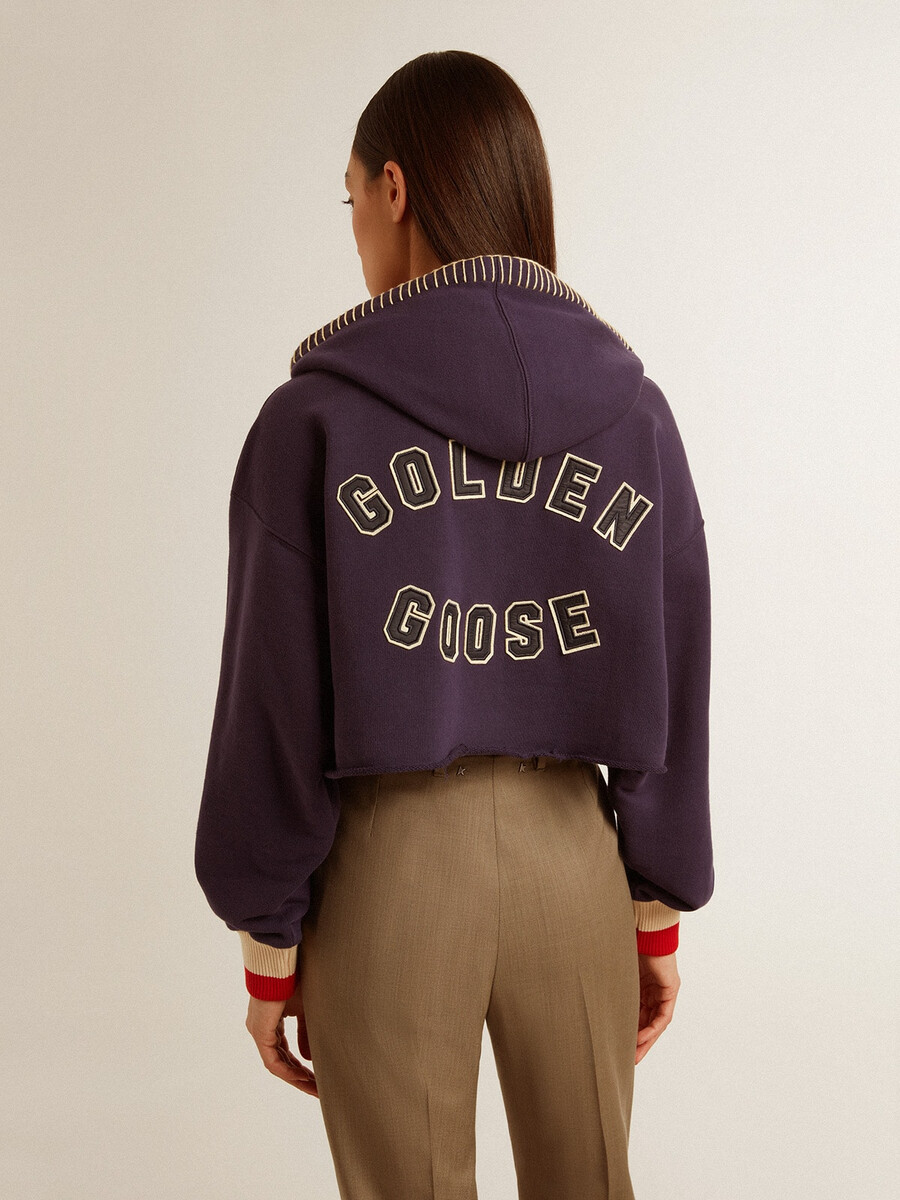 donkerblauwe cropped sweater met ritssluiting en geborduurde capuchon.