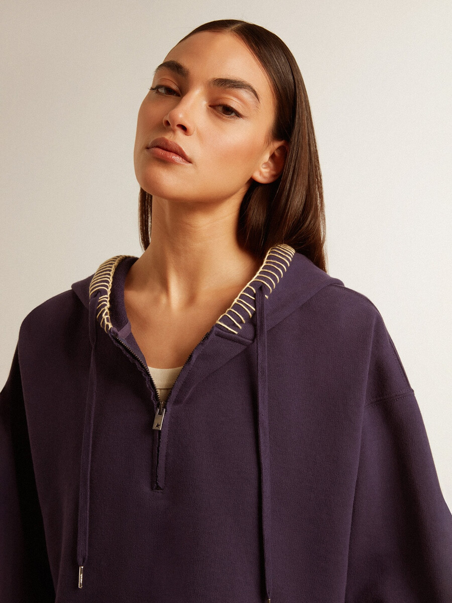 donkerblauwe cropped sweater met ritssluiting en geborduurde capuchon.