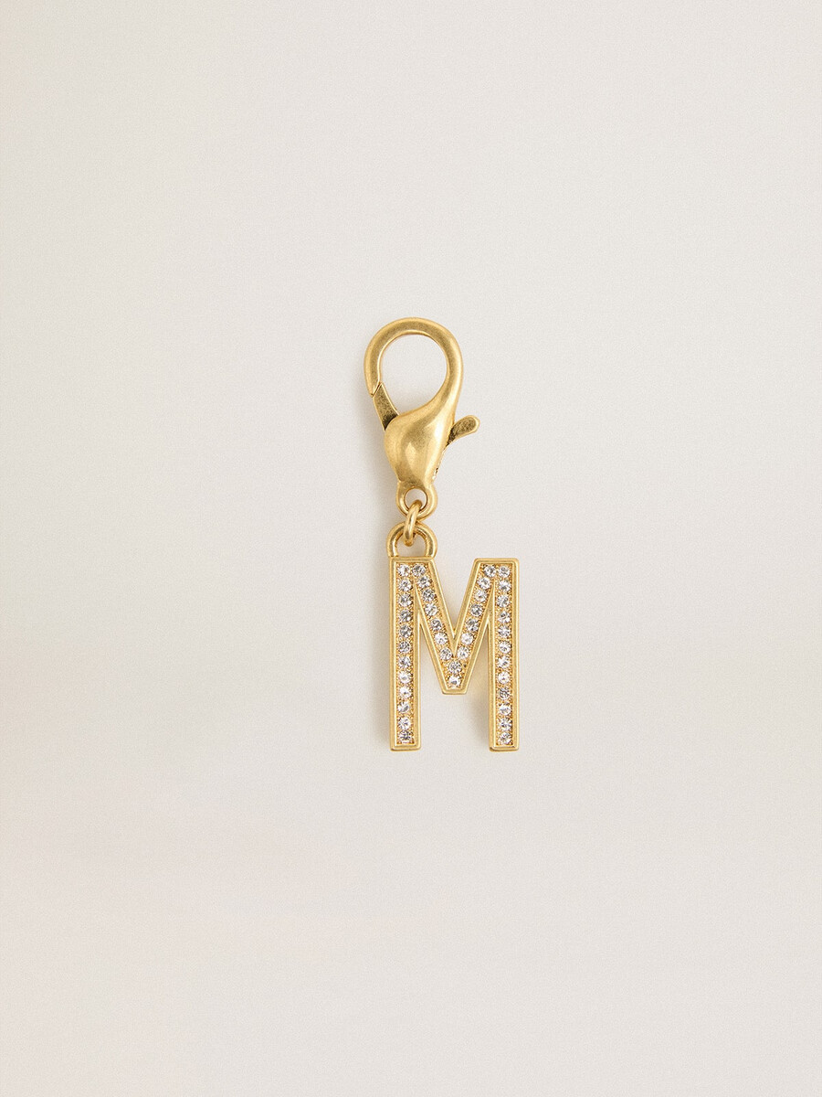 bedeltje met de letter m in goudkleurig messing met kristallen.