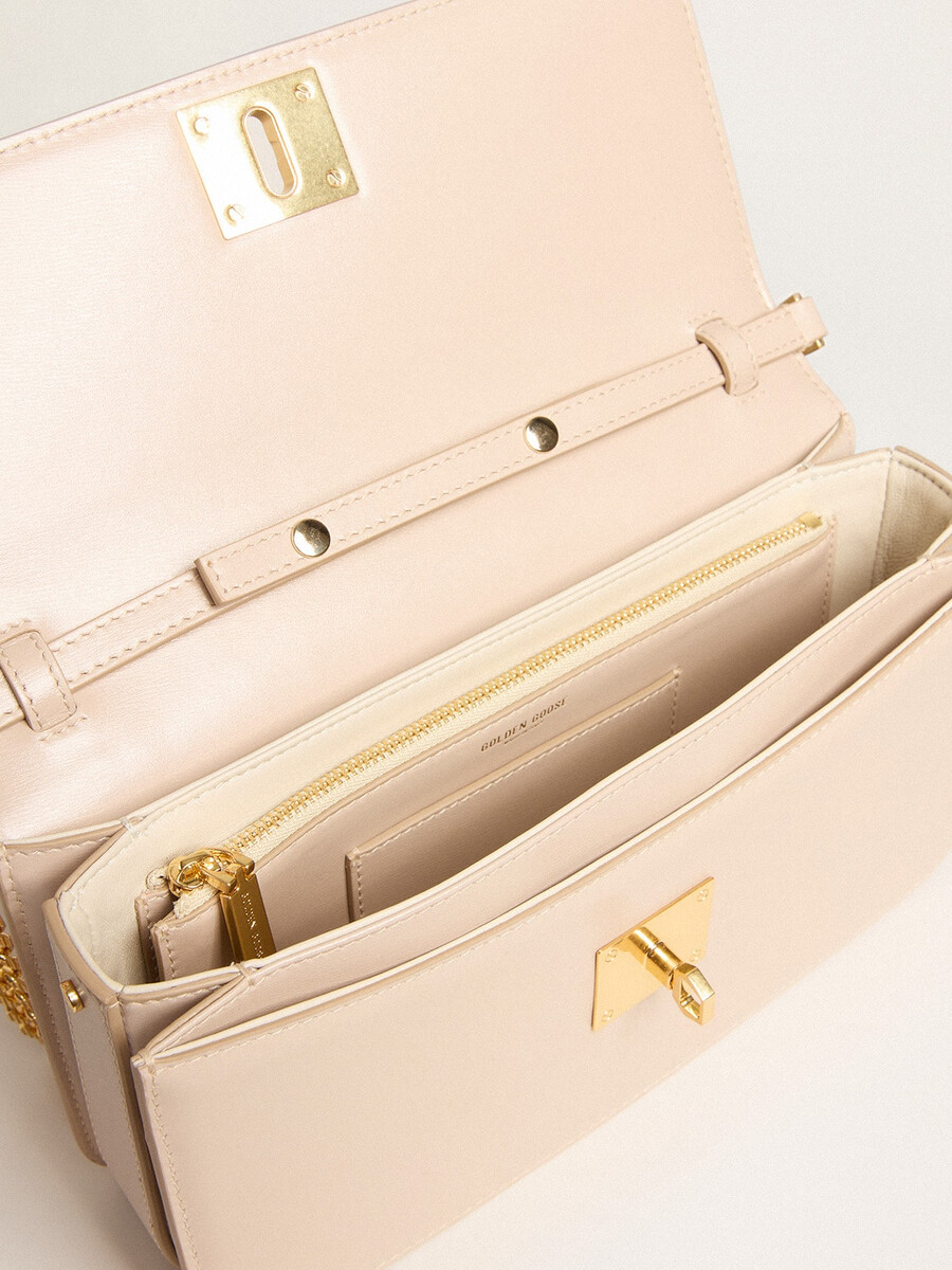 gioia-tas van lichtroze geribbeld leer met gouden details.