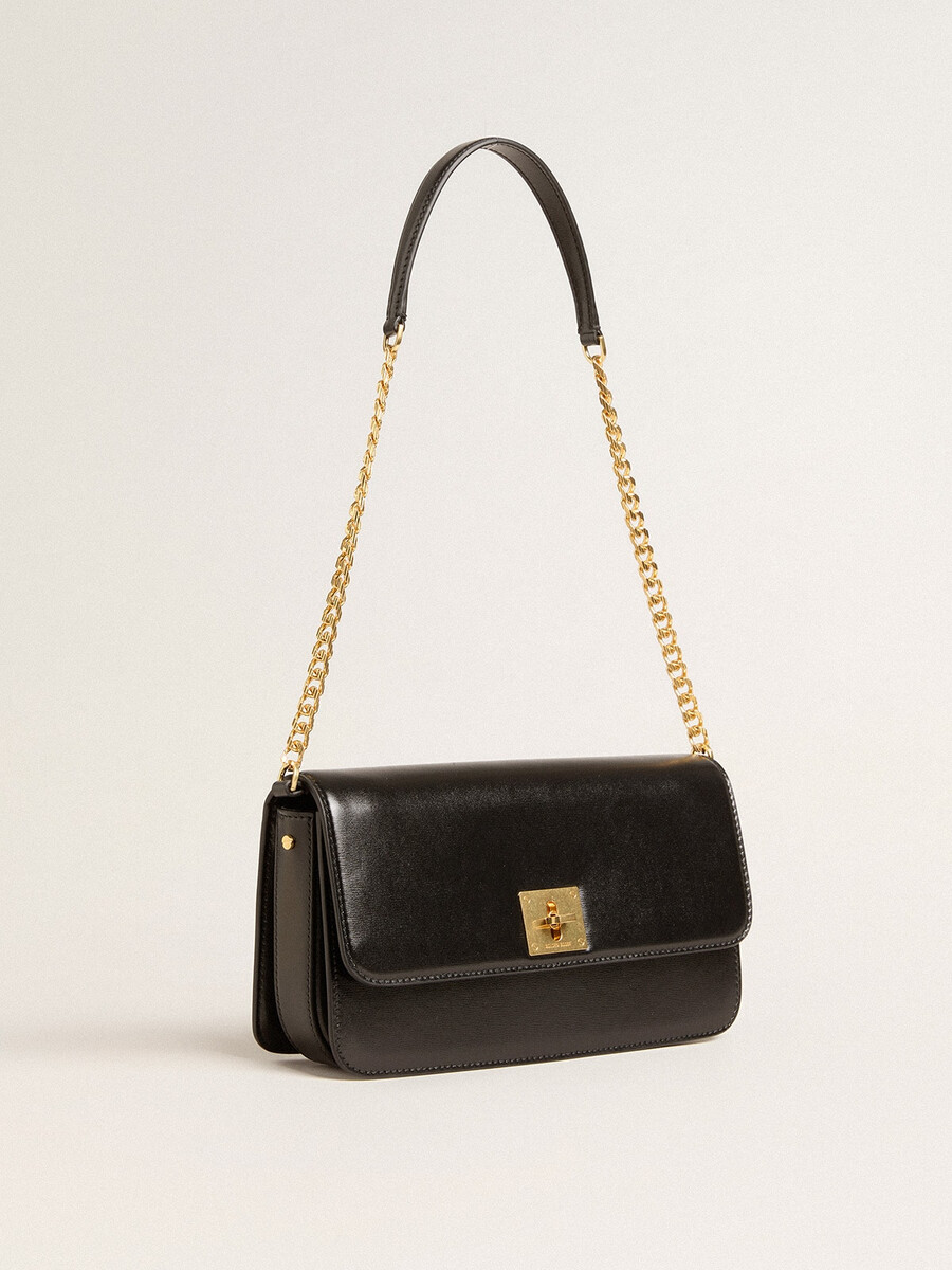 gioia-tas van zwart geribbeld leer met gouden details.