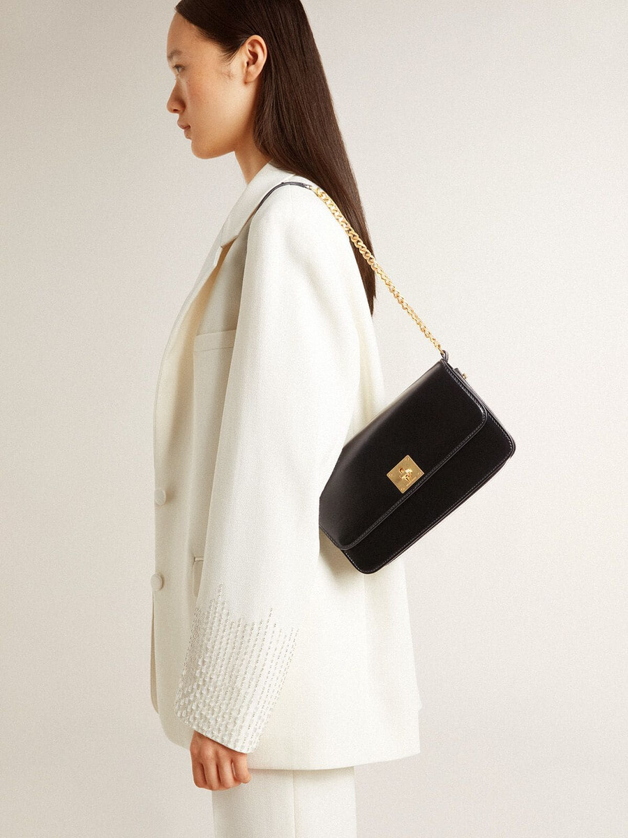 gioia-tas van zwart geribbeld leer met gouden details.