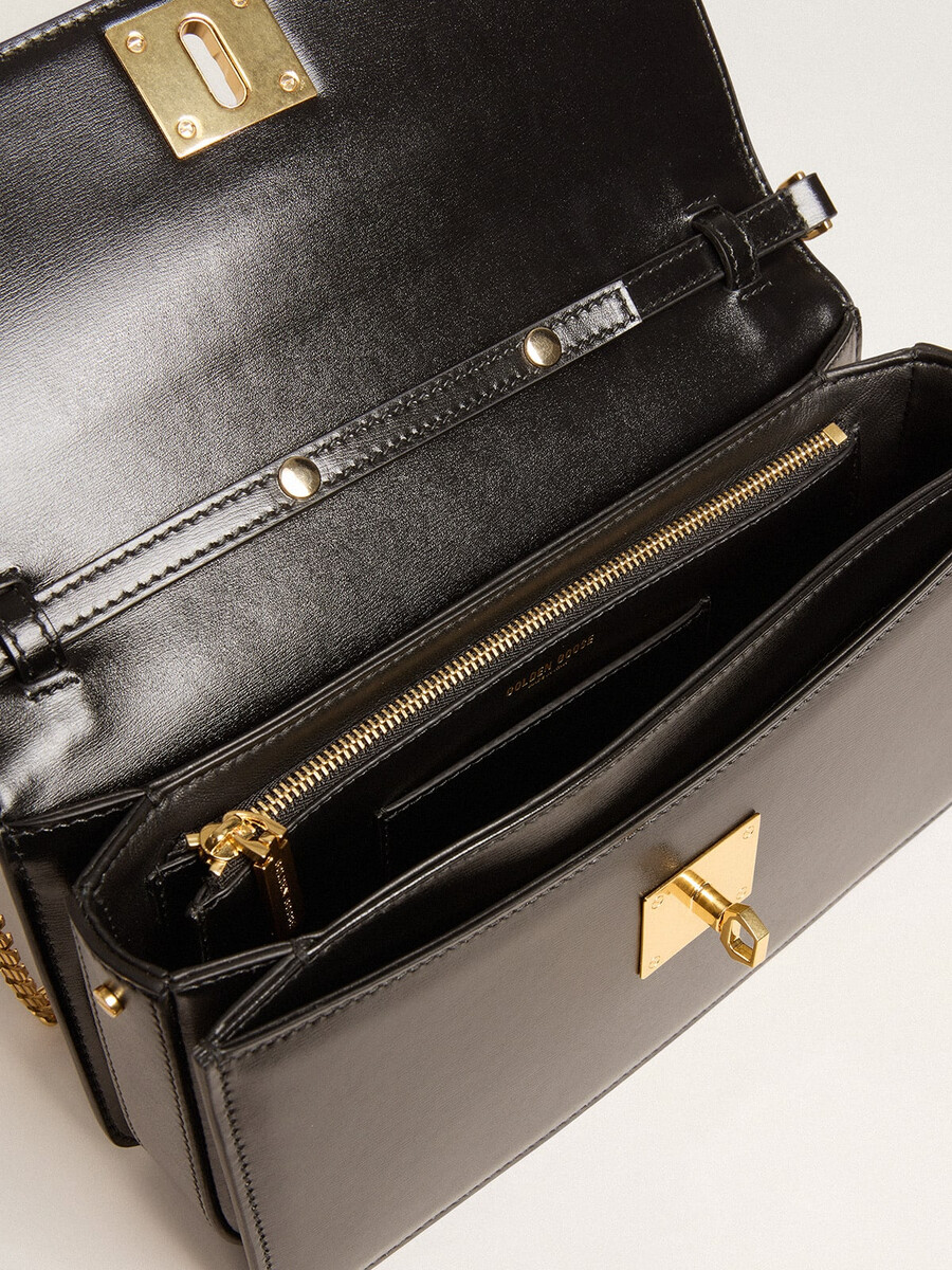 gioia-tas van zwart geribbeld leer met gouden details.