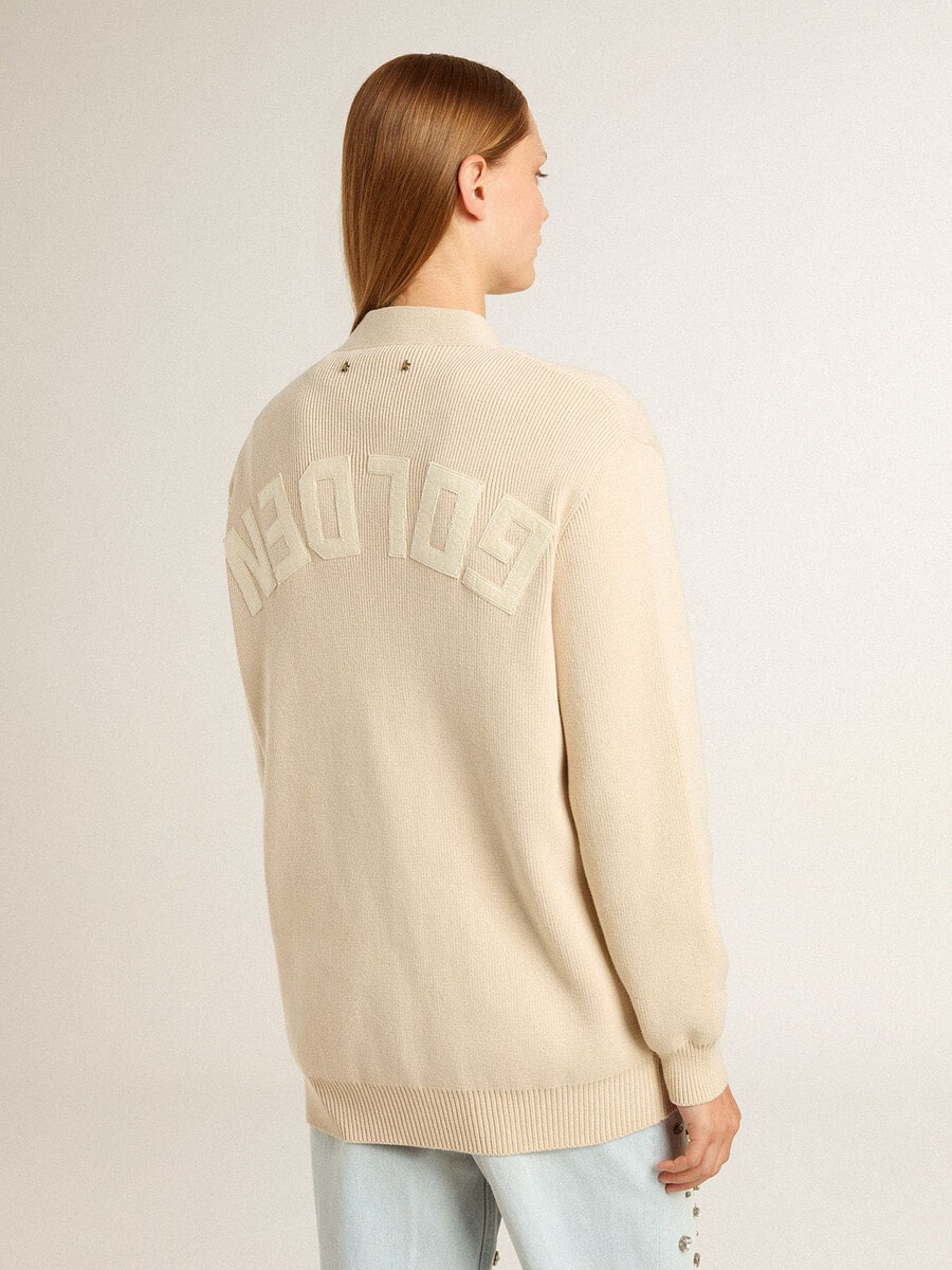 beige damesvest met golden-letters op de achterkant.