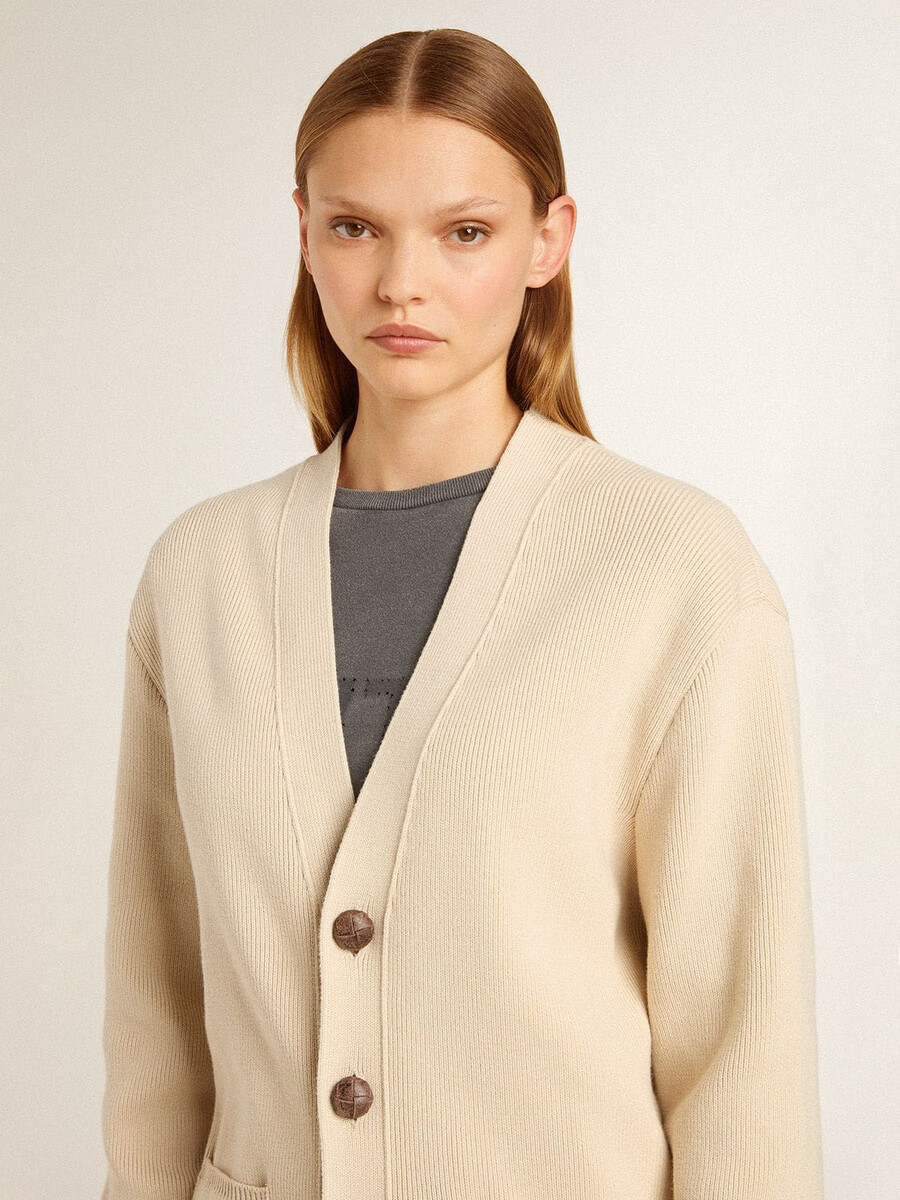 beige damesvest met golden-letters op de achterkant.