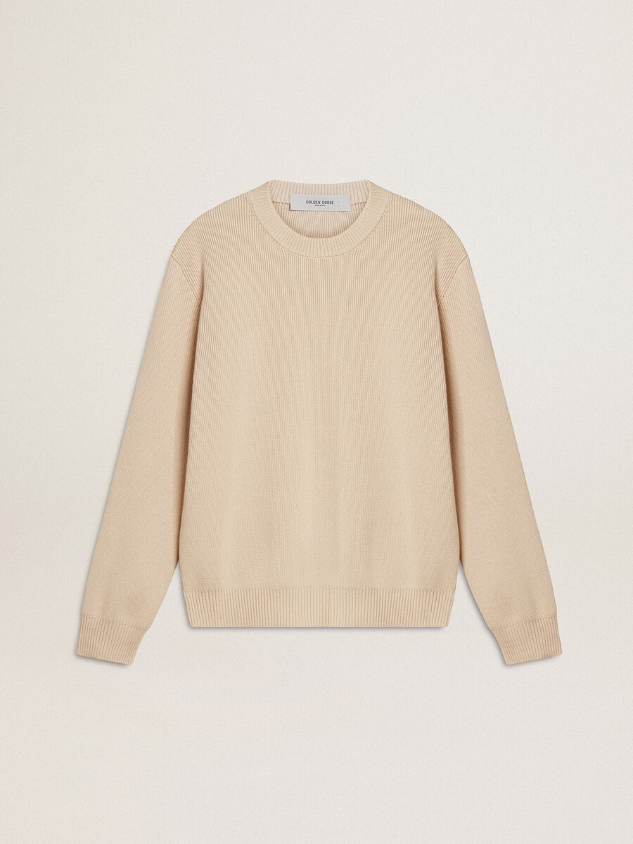 beige damestrui met golden-letters op de achterkant.