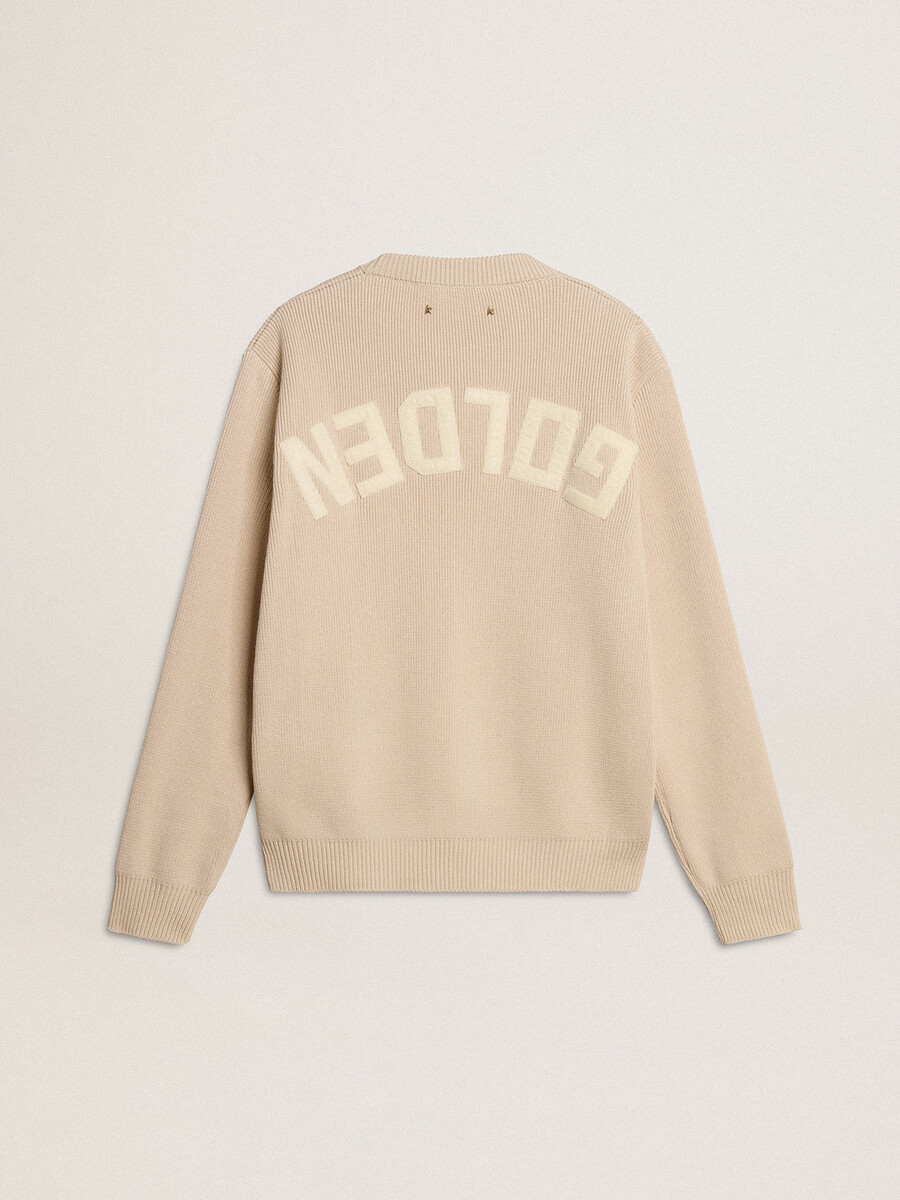 beige damestrui met golden-letters op de achterkant.
