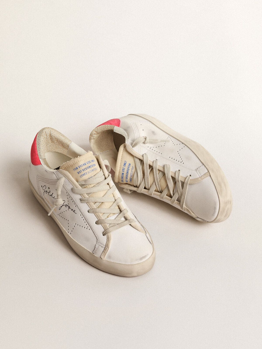 dames super-star van wit leer met geperforeerde ster en fuchsia nylon hielstuk.