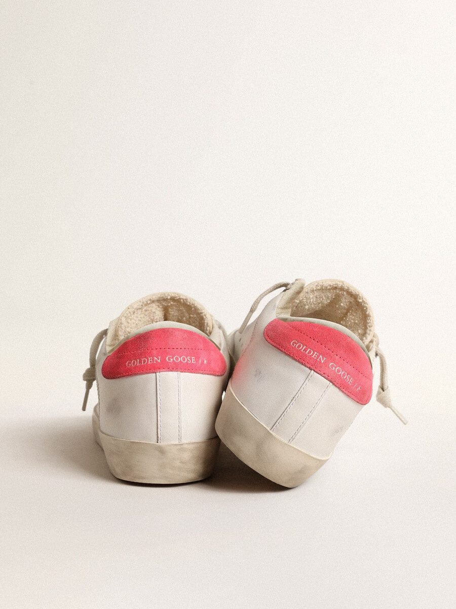 dames super-star van wit leer met geperforeerde ster en fuchsia nylon hielstuk.
