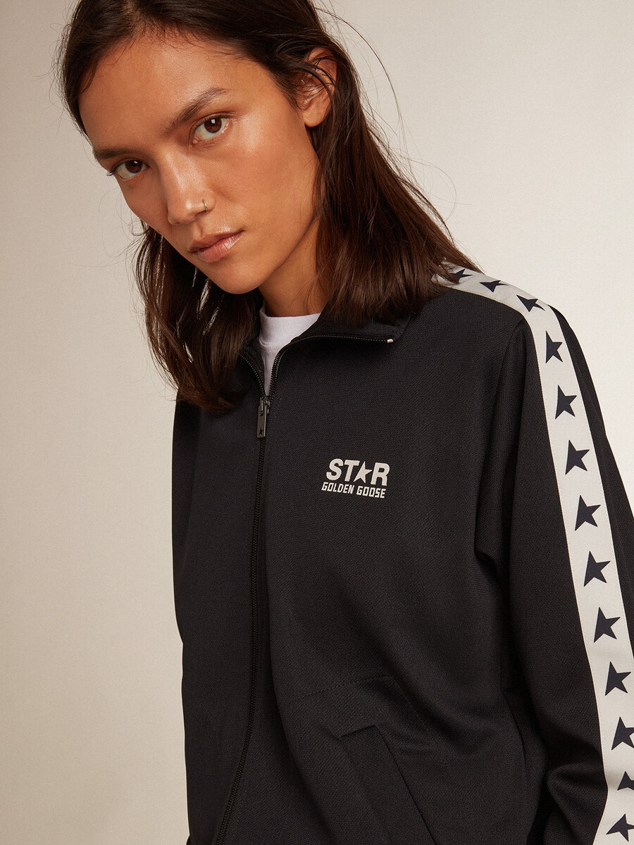 donkerblauwe sweater met rits witte streep en contrasterende sterren.