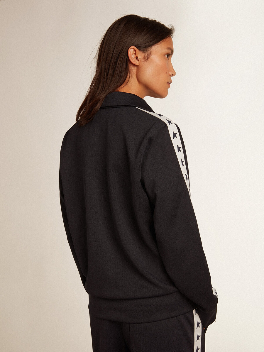 donkerblauwe sweater met rits witte streep en contrasterende sterren.