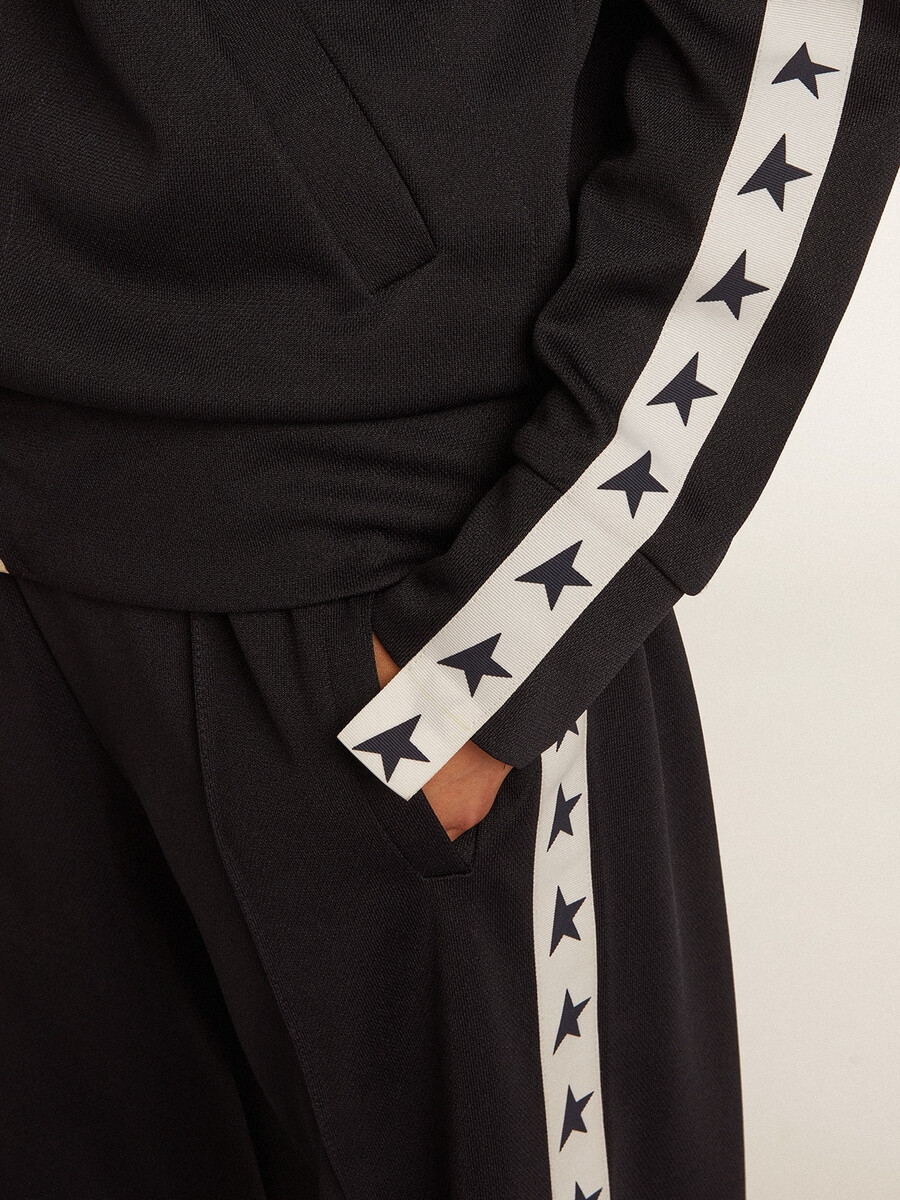 donkerblauwe sweater met rits witte streep en contrasterende sterren.